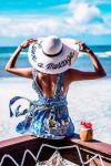 Девушка на пляже в легком платье и шляпке