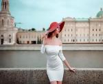Девушка в красной шляпе и белом платье на улице