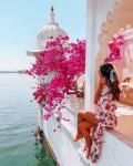 Девушка в летнем платье на балконе над морем