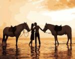 Влюбленная пара на прогулке с лошадьми у моря