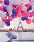 Девушка с огромным облаком воздушных шариков в Париже