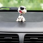 Собака на панель авто, качающая головой, далматин
